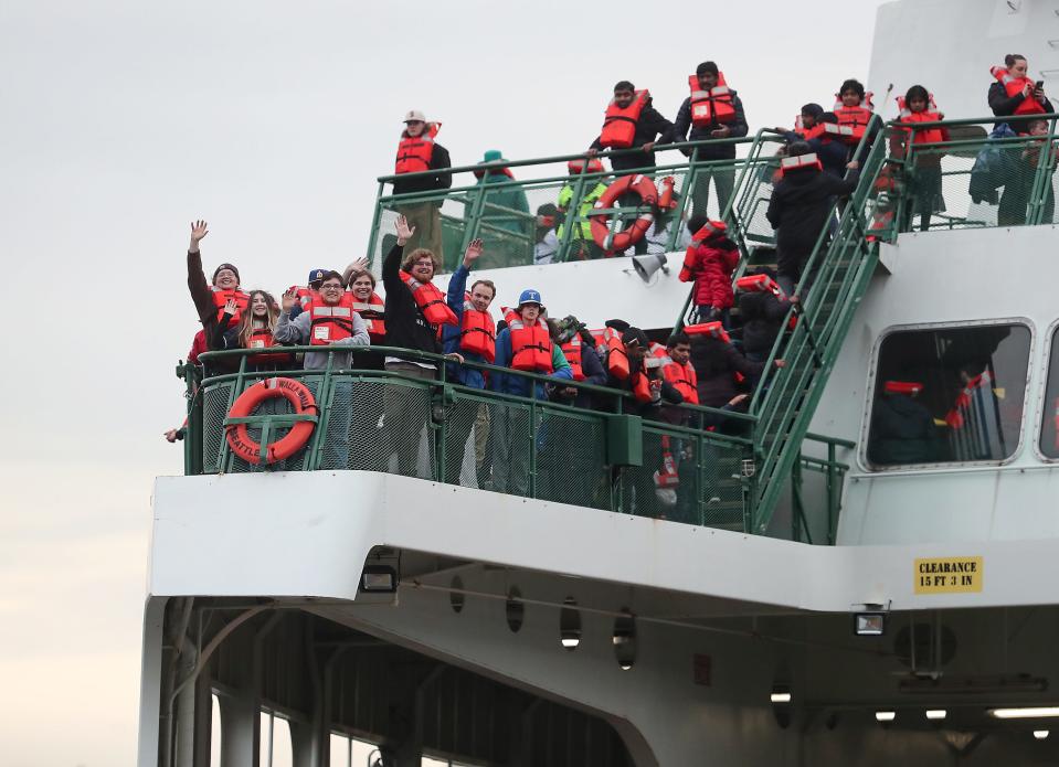 Passengers in lifejackets wave to those on the beach from the deck of the Washington State Ferry Walla Walla after it ran aground while transiting Rich Passage and ended up on the shore of Lynwood Center on Bainbridge Island on April 15.