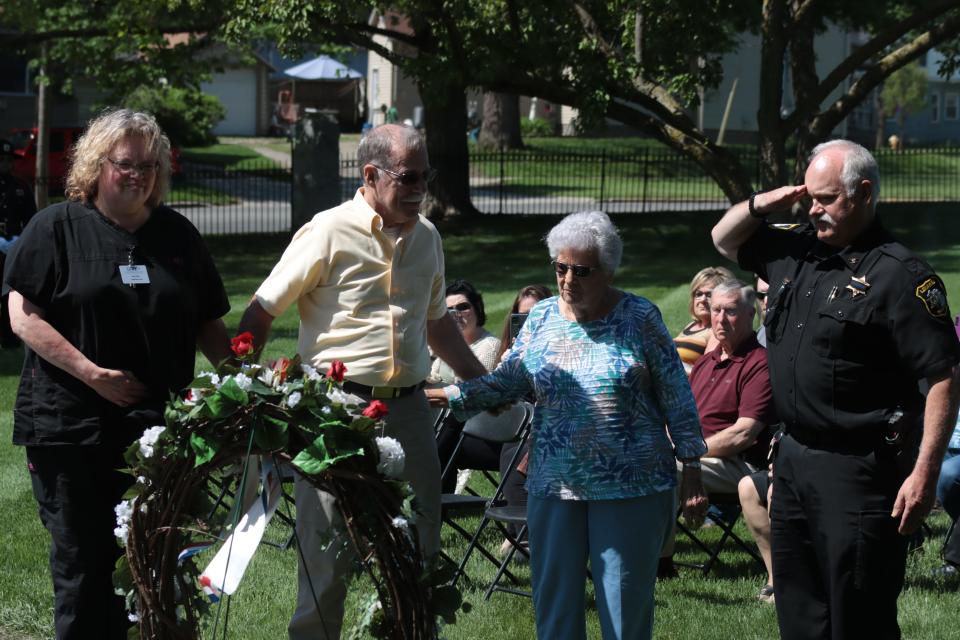 Lenawee County Undersheriff Jeff Ewald, right, salutes Monday after relatives of Clayton Constable Richard Teske — from left, daughter Susan Barber, son Gary Teske and sister Esther McNair — placed a rose for Teske in a wreath during the annual Peace Officers Memorial Day service at Oakwood Cemetery in Adrian.