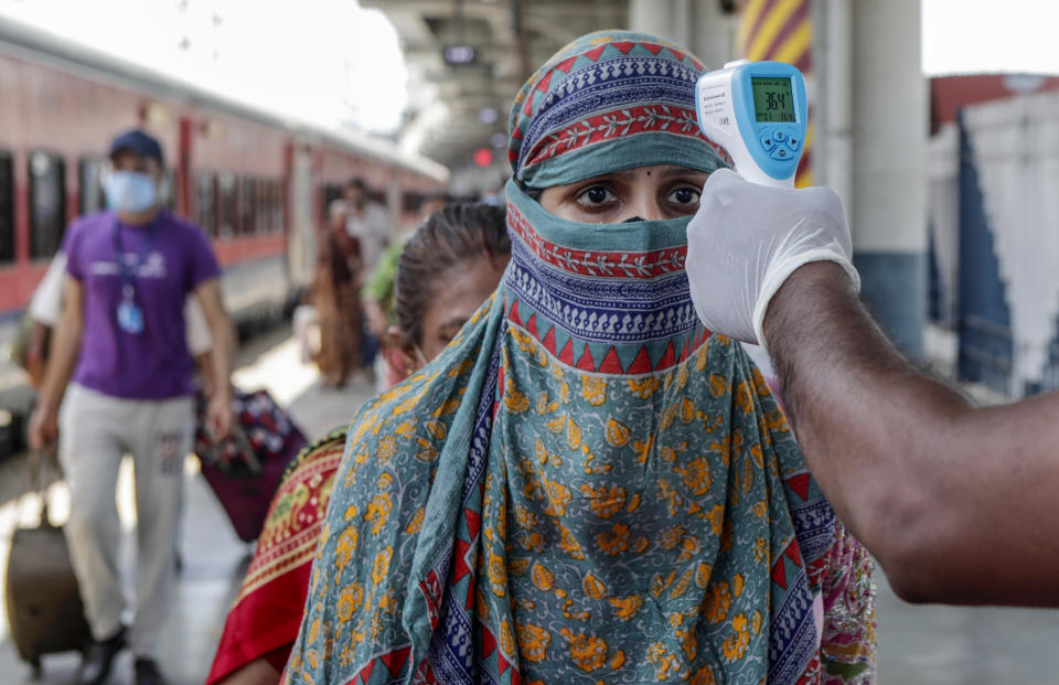 A health worker screening travelers to test for COVID-19 at train station in Mumbai, India, Monday, May 24,2020. India crossed another grim milestone Monday of more than 300,000 people lost to the coronavirus as a devastating surge of infections appeared to be easing in big cities but was swamping the poorer countryside. (AP Photo/Rajanish kakade)