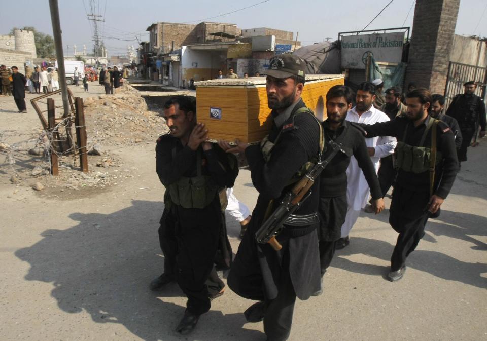 Pakistani security personnel carry the body of a fellow officer, who was killed in Saturday bomb blasts during their funeral procession, in Jamrud, near Peshawar, Pakistan, Saturday, March 1, 2014. The Pakistani Taliban announced Saturday that the group will observe a one-month cease-fire as part of efforts to negotiate a peace deal with the government, throwing new life into a foundering peace process. The violence Saturday showed how difficult it could be to enforce a cease-fire, let alone forge a peace agreement. (AP Photo/Mohammad Sajjad)