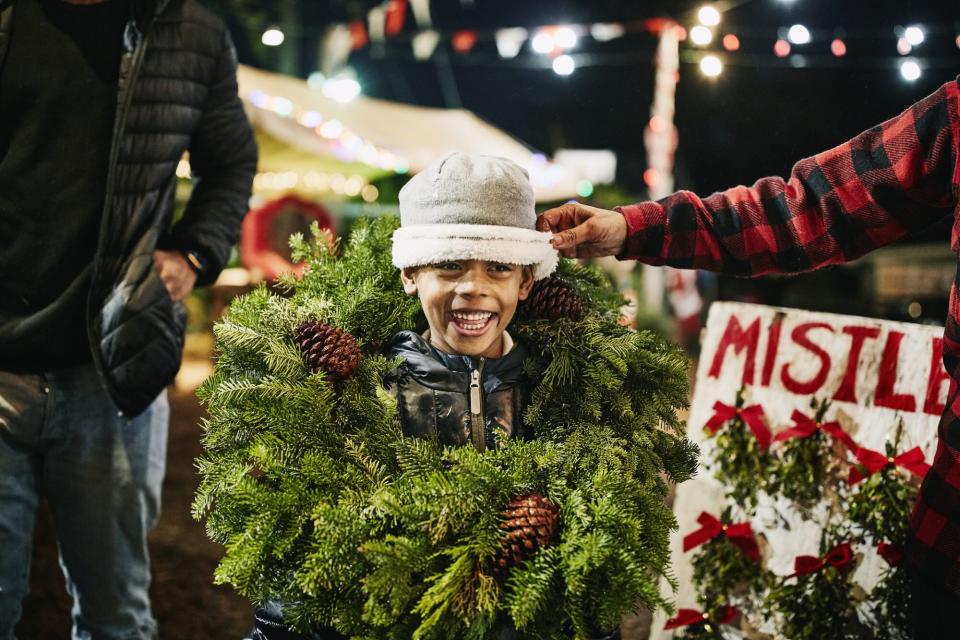An image of a boy with a wreath around him.