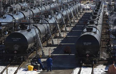 Irving Oil workers inspect rail cars carrying crude oil at the Irving Oil rail yard terminal in Saint John, New Brunswick, March 9, 2014. REUTERS/Devaan Ingraham