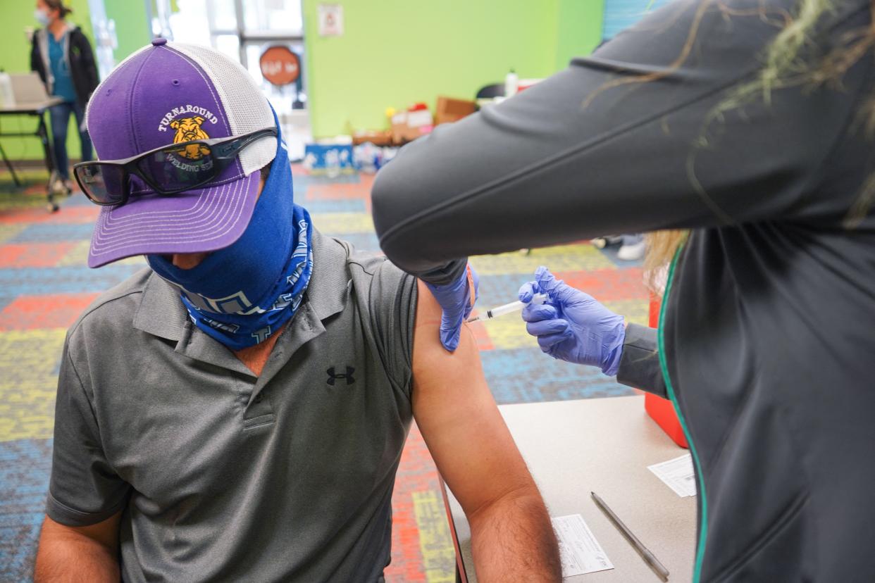 A healthcare vaccinates a man with the Covid-19 vaccine on April 30, 2021,as the Pasadena Public Library hosts a mobile vaccine clinic set up by the Harris County Public Health, in Pasadena, Texas. (Cecile Clocheret/AFP via Getty Images)