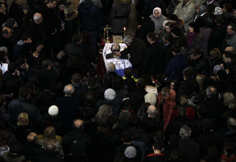 An open casket with the body of Bogdan Solchunuk, 28, lays in the centre of St. Paul and Peter church, during his funeral service in Lviv, western Ukraine, Saturday, Feb. 22, 2014. Church services were held Saturday in the pro-opposition stronghold of Lviv in the west of Ukraine for the locals who were killed in Kiev during the past week. Lviv activists say 19 of their people were killed in the violence at Maidan. (AP Photo/Darko Vojinovic)