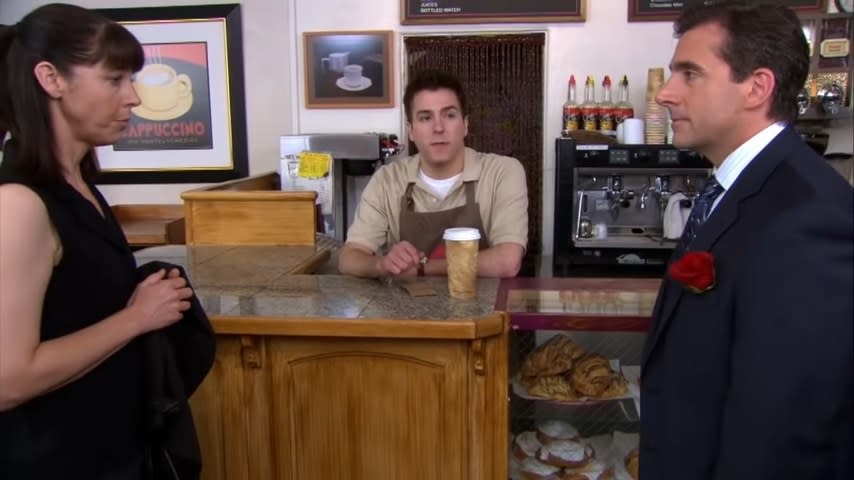 Michael standing in front of Pam's landlady in a coffee shop in "The Office"