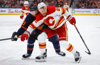 Calgary Flames forward Trevor Lewis, right, holds back Edmonton Oilers winger Zach Hyman during the third period of Game 4 of an NHL hockey Stanley Cup playoffs second-round series Tuesday, May 24, 2022, in Edmonton, Alberta. (Jeff McIntosh/The Canadian Press via AP)