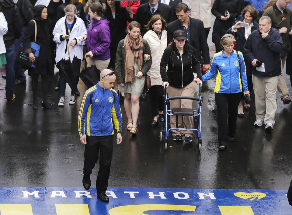 CORRECTS TO BRANNOCK FROM BRANNICK- Marathon survivor Erika Brannock, a teacher from Maryland, uses a walker as she prepares to cross the finish line following a tribute in honor of the one year anniversary of the Boston Marathon bombings, Tuesday, April 15, 2014 in Boston. (AP Photo/Charles Krupa)