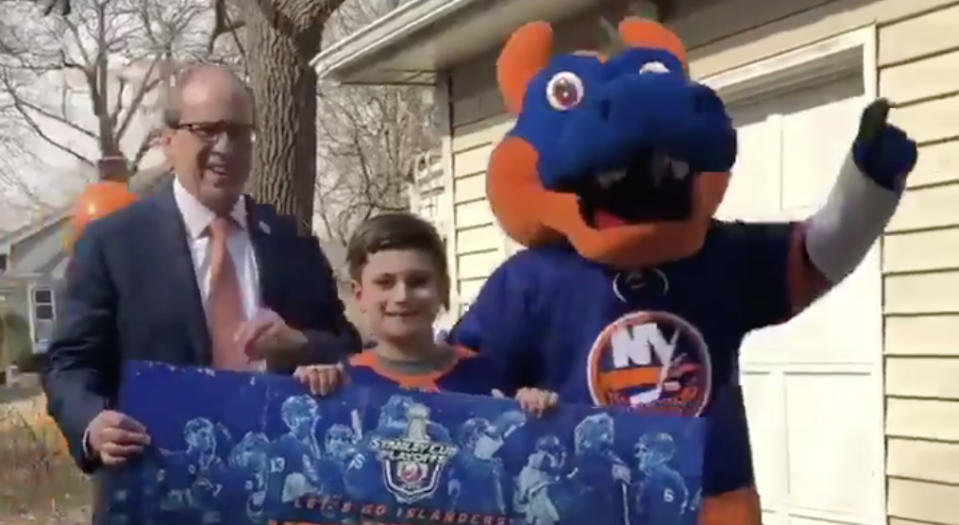 New York Islanders owner Jon Ledecky, left, is joined by team mascot Sparky the Dragon to present 11-year-old Peyton Wilson, middle, with four tickets to Game 1 of the Islanders’ first round series against the Pittsburgh Penguins. (Twitter//@NYIslanders)