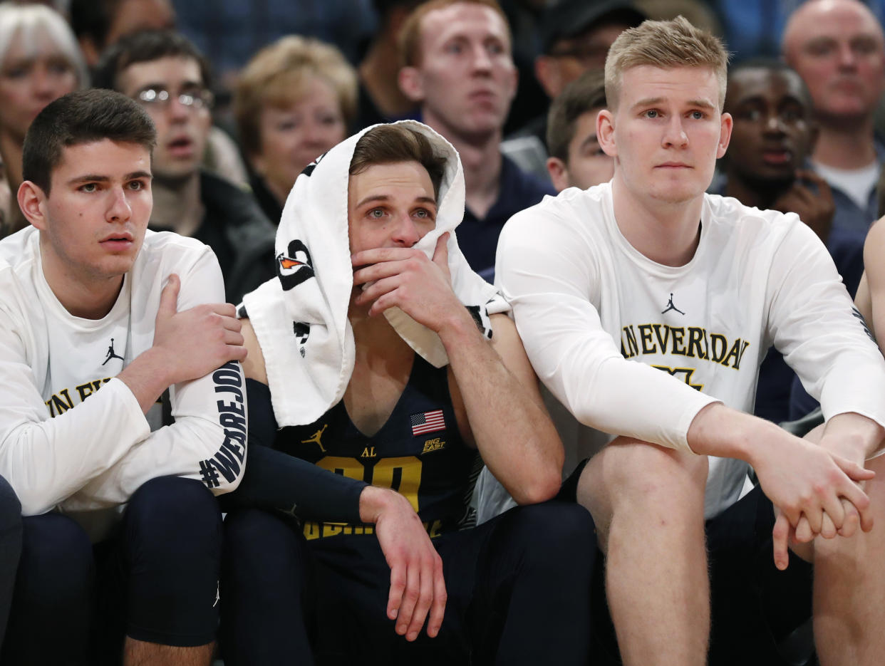 Marquette players, including guard Andrew Rowsey, center, with towel over his head, watch the waning minutes of the team’s NCAA college basketball game against Villanova in the Big East men’s tournament quarterfinals in New York, Thursday, March 8, 2018. Villanova defeated Marquette 94-70. (AP Photo/Kathy Willens)