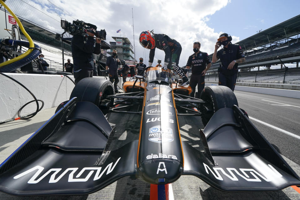 Helio Castroneves, of Brazil, climbs into his car during a practice session for an IndyCar auto race at Indianapolis Motor Speedway, Thursday, Oct. 1, 2020, in Indianapolis. (AP Photo/Darron Cummings)