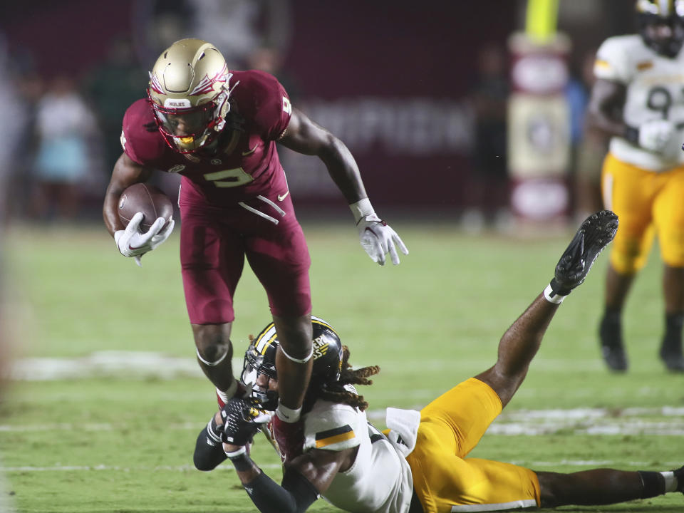 Florida State running back Lawrance Toafili, top, leaps after making a long run after a catch as Southern Mississippi safety Dylan Lawrence, bottom, dives to tackle him in the first quarter of an NCAA college football game Saturday, Sept. 9, 2023, in Tallahassee, Fla. (AP Photo/Phil Sears)