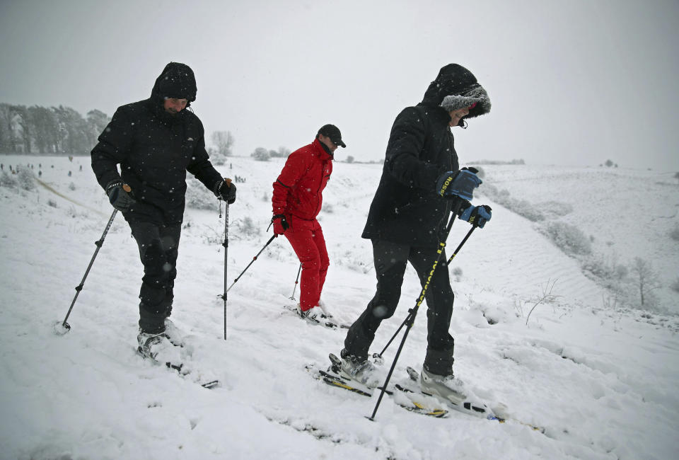 Skiers make their way through the snow in Wye National Nature Reserve near Ashford, south east England, Sunday Feb. 7, 2021, with bitterly cold winds and heavy snow set to bring disruption to some parts of England. (Andrew Matthews/PA via AP)