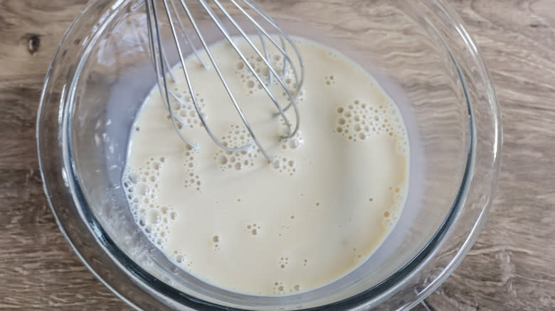 milk and whisk in bowl