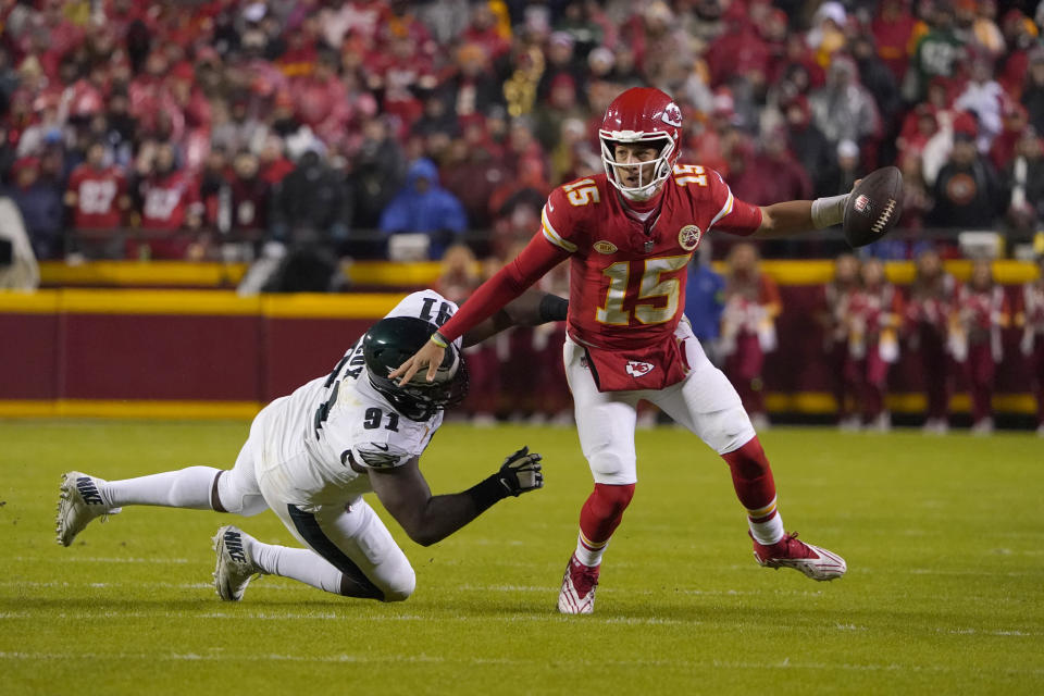 Kansas City Chiefs quarterback Patrick Mahomes (15) scrambles for a first down past Philadelphia Eagles defensive tackle Fletcher Cox (91) during the first half of an NFL football game, Monday, Nov. 20, 2023, in Kansas City, Mo. (AP Photo/Ed Zurga)