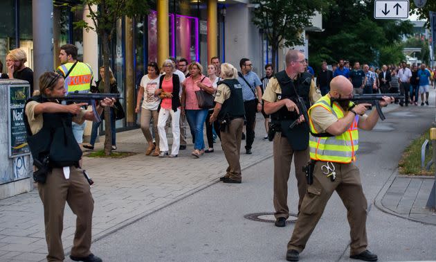 Police officers guard with guns as other officers escort people from inside the shopping center as they respond to the shooting at the Olympia Einkaufzentrum on Friday (Photo: Joerg Koch via Getty Images)