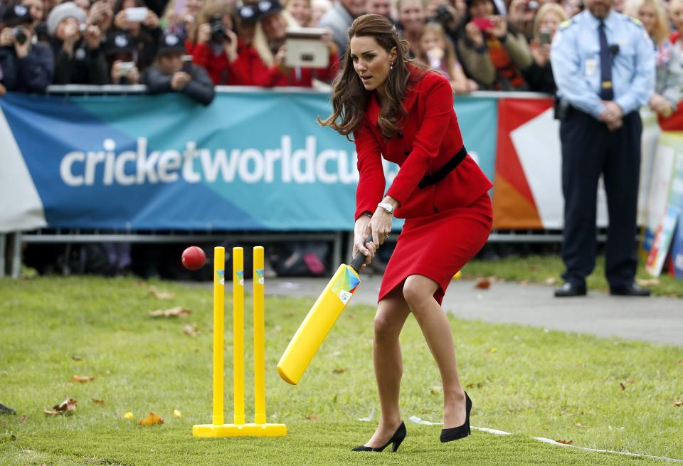 Catherine, the Duchess of Cambridge, tries to hit a ball using a cricket bat as she and her husband, Britain's Prince William, attend a promotional event for the upcoming Cricket World Cup in Christchurch