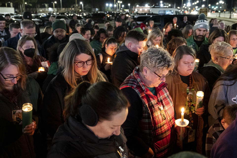 Los asistentes a una vigilia agachan la cabeza para orar por Abby Zwerner, una maestra herida a disparos por un estudiante de 6 años en la escuela primaria Richneck, la noche del lunes 9 de enero de 2023 frente al edificio de administración de las escuelas públicas de Newport News, Virginia. (Billy Schuerman/The Virginian-Pilot vía AP)