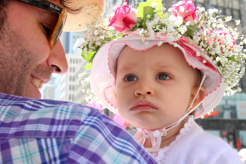 Secho Rodriguez, left, holds his 14 month old daughter Caetana Boente Rodriguez as they make their way along New York's Fifth Avenue during the Easter Parade, Sunday, April 20, 2014. (AP Photo/Tina Fineberg)