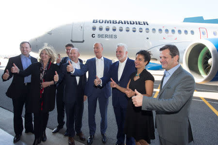 Alain Bellemare (4th L), president and chief executive officer of Bombardier Inc., Airbus Chief Executive Tom Enders (4th R) and Quebec premier Philippe Couilard (3rd R) give a thumbs up with other dignitaries and executives in front of a Bombardier C Series plane at Bombardier's plant in Mirabel, Quebec Canada, October 20, 2017. REUTERS/Christinne Muschi