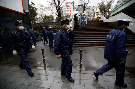 Police officers walk as they guard inside the barricade fences at a gate of Miyashita park in Tokyo, Japan March 27, 2017. REUTERS/Issei Kato