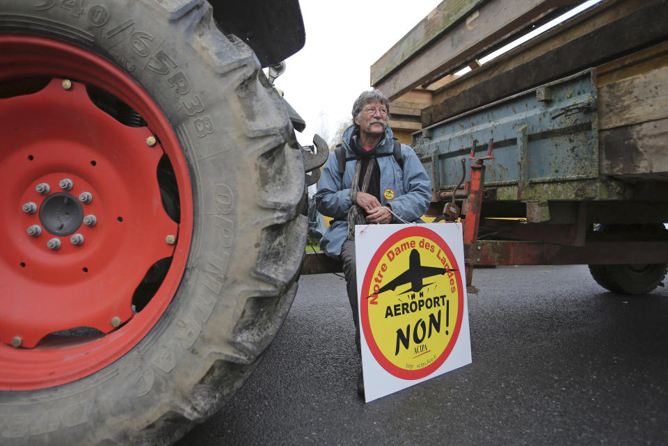 FILE - This Nov. 17, 2012 file photo shows a demonstrator holding a sign reading: "Airport No", on a road near Notre Dame des Landes, western France, as part of a protest against a project to build an international airport, in Notre Dame des Landes, near Nantes. An unlikely alliance of anarchists and beret-wearing farmers is creating a headache for President Francois Hollande’s beleaguered government by mounting an escalating Occupy Wall Street-style battle that has delayed construction on the ambitious airport near the city of Nantes for months. (AP Photo/David Vincent, File)