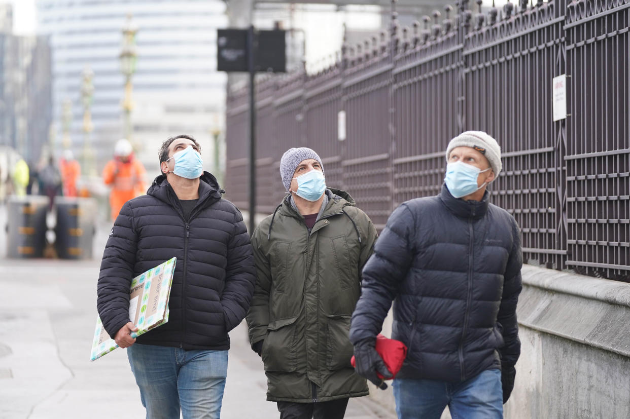 People wearing masks walking in Westminster, London.