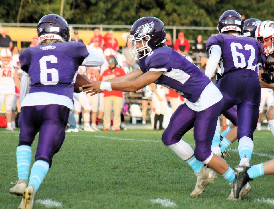 Marshwood quarterback Tyler Hussey (left) hands the ball off to Dylan Grassi during Friday's game against Sanford in South Berwick, Maine.