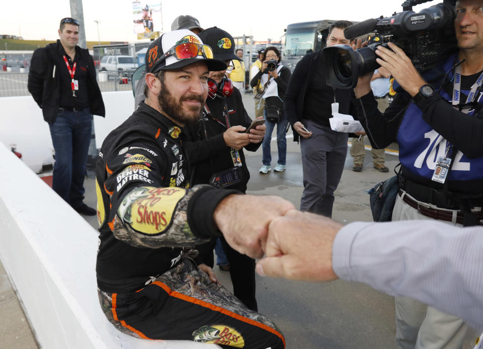 Martin Truex Jr. is congratulated after winning the pole for the NASCAR Cup Series auto race at Kansas Speedway in Kansas City, Kan., Friday, Oct. 20, 2017. (AP Photo/Colin E. Braley)