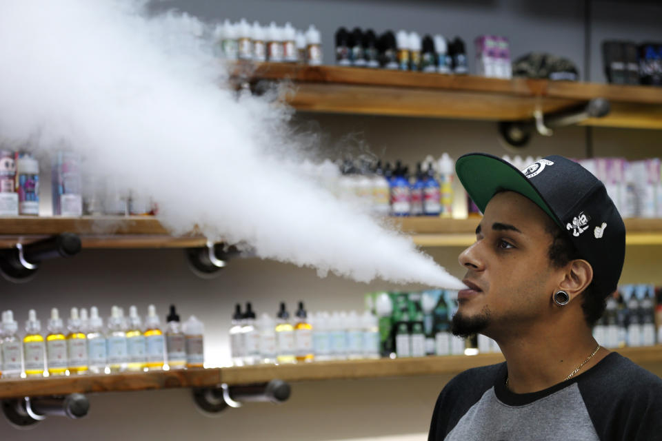 In this Tuesday, Sept. 3, 2019, photo, Andrew Teasley, a salesman at Good Guys Vape Shop, exhales vapor while using an e-cigarette in Biddeford, Maine. Efforts to ban flavored e-cigarettes and reduce their appeal to youngsters have sputtered under industry pressure in over a half-dozen states this year. The industry and its lobbyists urged lawmakers to leave mint and menthol alone. A proposed ban that President Donald Trump outlined Wednesday, Sept. 11, would supersede any state inaction and includes a ban on mint and menthol. (AP Photo/Robert F. Bukaty)