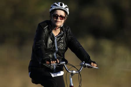 Brazil's President Dilma Rousseff rides her bicycle near the Alvorada Palace in Brasilia, July 27, 2015. REUTERS/Ueslei Marcelino