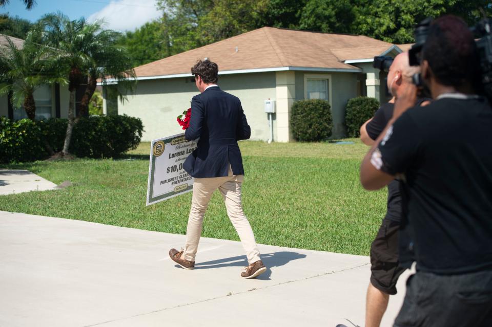 In a real Publishers Clearing House sweepstakes moment, Lorena Logan is surprised with a $10,000 check by Howie Guja of the Prize Patrol Elite Team on Thursday, March 17, 2022, at the Logan home in Port St. Lucie, Florida. Lorena Logan has entered the sweepstakes every day for at least 30 days, Guja said. Guja made two attempts to reach her, first surprising her daughter Ashley with the winnings. Ashley Logan called her mother about 30 times to get her home. “My volume was way down,” Lorena Logan said.