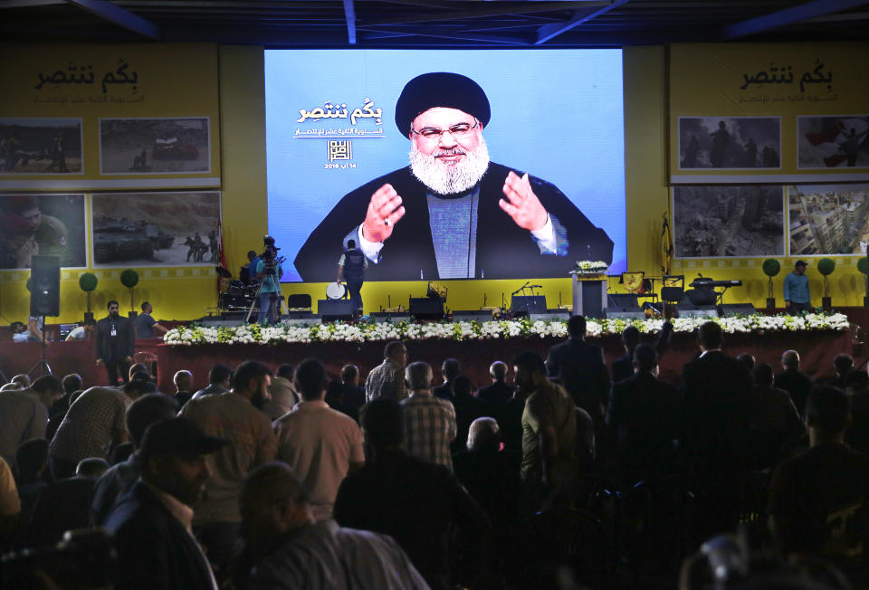 Hezbollah leader Sayyed Hassan Nasrallah delivers a broadcast speech through a giant screen, during a rally marking the12th anniversary of the 2006 Israel-Hezbollah war, in Beirut, Lebanon, Tuesday, Aug. 14, 2018. The leader of Lebanon's militant Hezbollah group says U.S. sanctions against Iran and his group will not have major effects on them. (AP Photo/Hussein Malla)