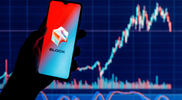 Square, Inc. changes name to Block (SQ). Smartphone with Block logo on screen in hand on background of stock market chart.