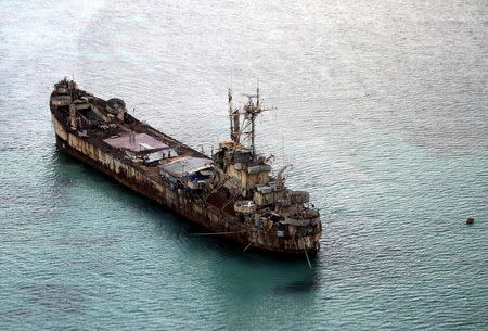 Filipino soldiers wave from the dilapidated Sierra Madre ship of the Philippine Navy as it is anchored near Ayungin shoal (Second Thomas Shoal) in the Spratly group of islands in the South China Sea, west of Palawan, Philippines, May 11, 2015. REUTERS/Ritchie A. Tongo/Pool