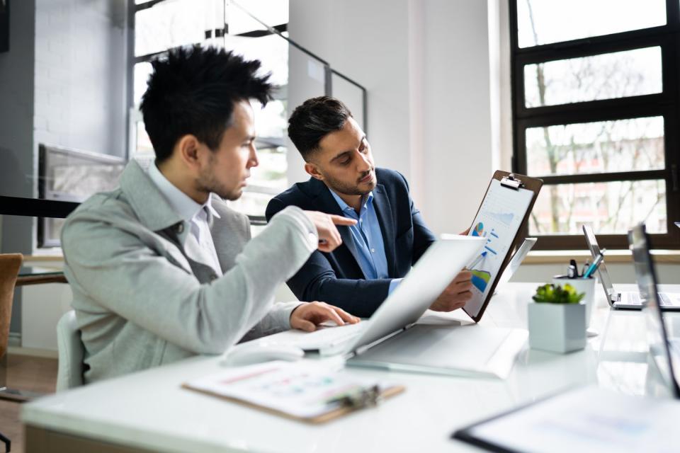 Two people in an office discussing documents.