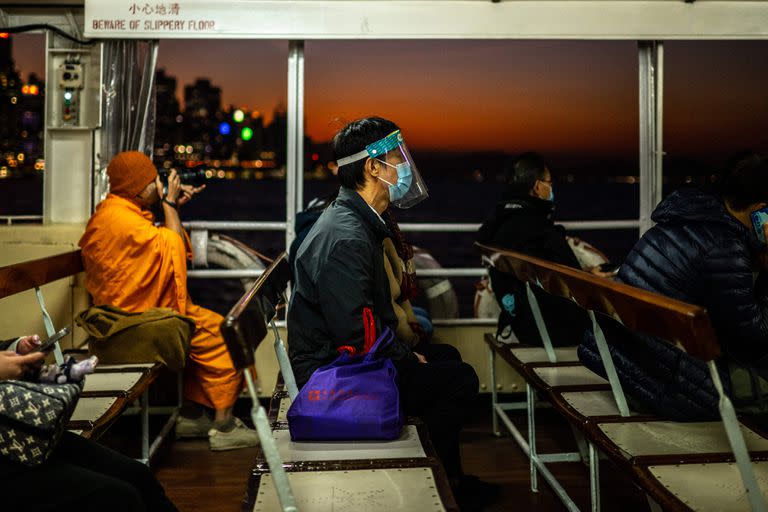 Un pasajero con una máscara viaja en un ferry hacia el lado de Kowloon, en Hong Kong, el 19 de diciembre de 2022.