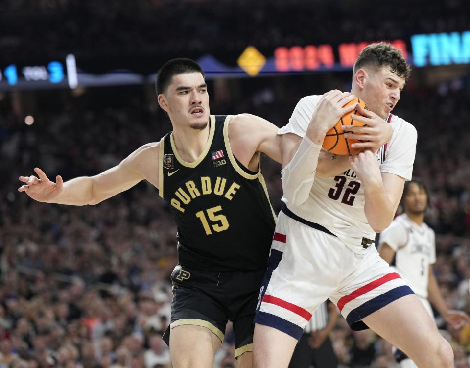 Purdue Boilermakers center Zach Edey (15) reaches in on Connecticut Huskies center Donovan Clingan (32) during the Men's NCAA national championship game at State Farm Stadium in Glendale on April 8, 2024.