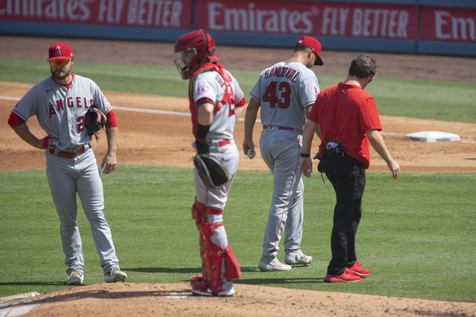 Los Angeles Angels starting pitcher Patrick Sandoval, second from right, exits with an injury during the third inning of a baseball game against the Los Angeles Dodgers in Los Angeles, Sunday, Sept. 27, 2020. (AP Photo/Kyusung Gong)