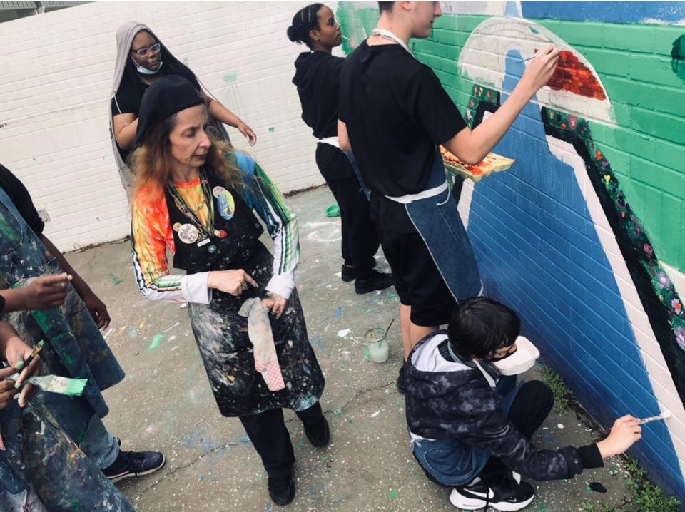 Lake Weir Middle School students studying with arts educator Lisa Russo, center, have spent this semester working on three murals on campus.