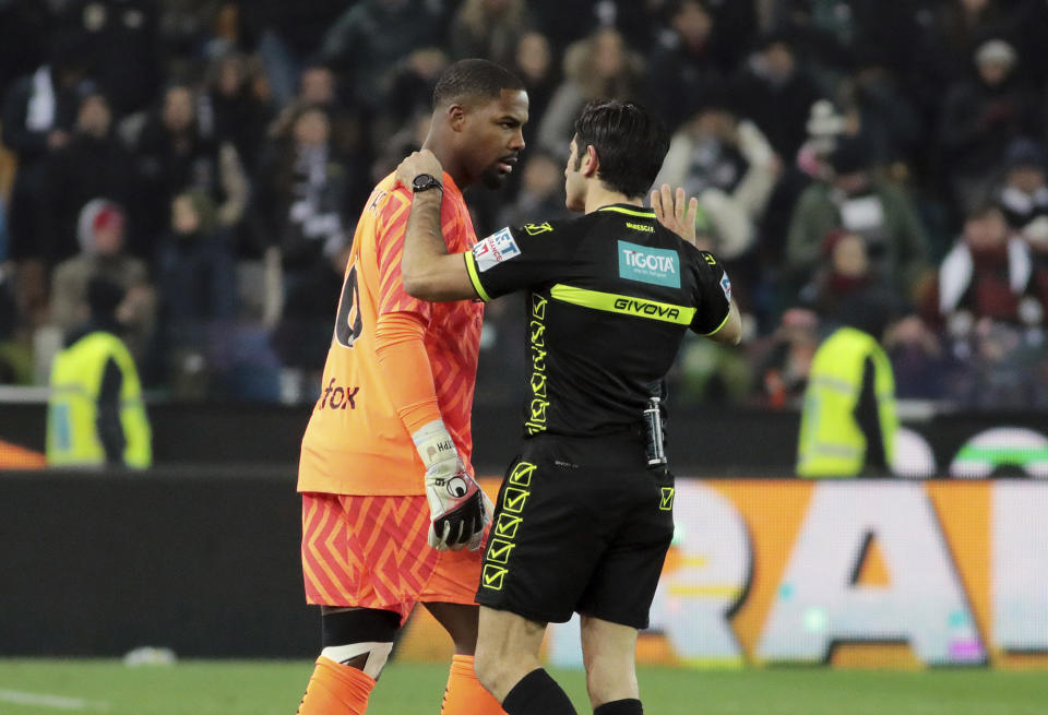 Referee Enzo Maresca, right, speaks to AC Milan's Mike Maignan during the Italian Serie A soccer match between Udinese and AC Milan that was suspended, at the Friuli stadium in Udine, Italy, Saturday, Jan. 20, 2024. Racist abuse aimed at AC Milan goalkeeper Mike Maignan prompted a top-tier Italian league game at Udinese to be suspended briefly during the first half. Maignan left the field after the insults which followed a goal for Milan. (Andrea Bressanutti/LaPresse via AP)