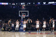 New York Knicks and Brooklyn Nets players stand on the court allowing the 24 second clock to wind down in a tribute to retired Los Angeles Lakers star Kobe Bryant at the start of an NBA basketball game in Madison Square Garden in New York, Sunday, Jan. 26, 2020. Bryant died in a helicopter crash in California earlier Sunday. (AP Photo/Kathy Willens)