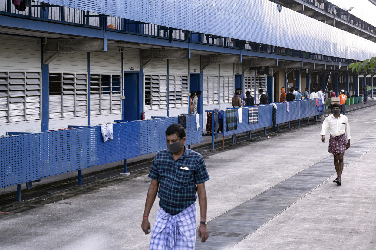 Trabajadores migrantes con máscaras protectoras salen de sus alojamientos en Singapur, el 8 de abril de 2020, durante la pandemia del coronavirus. (Ore Huiying/The New York Times)