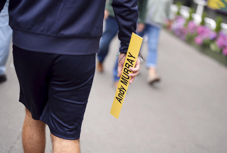 A member of the ground staff removes the name of Andy Murray from an order of play board after his withdrawal from the men's singles on day two of the Wimbledon tennis championships in London, Tuesday, July 2, 2024. Murray will play only doubles at his last appearance at the All England Club following his withdrawal from singles after back surgery. (Zac Goodwin/PA via AP)