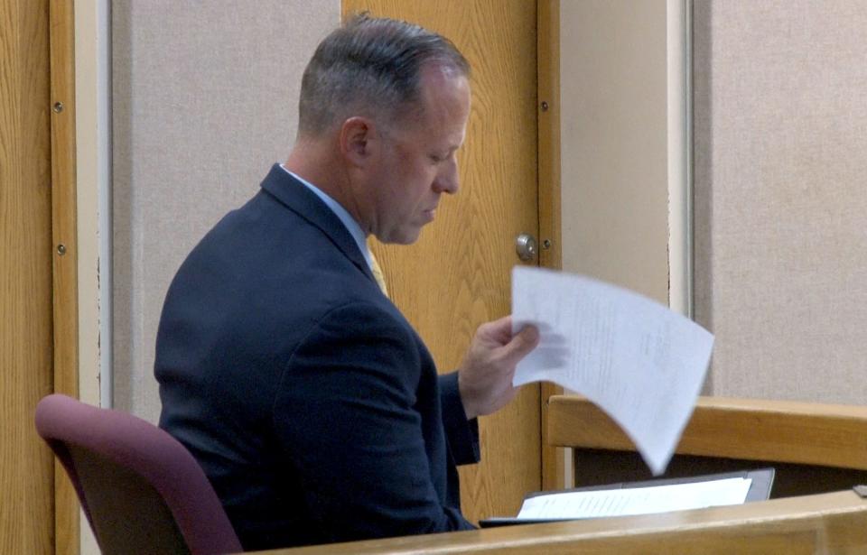 Former Howell Township Police Chief Andrew Kudrick looks thru his plea agreement as he pleads guilty to providing false statements in a township investigation and trying to conceal a sexual affair with a subordinate during a hearing before Superior Court Judge Paul X. Escandon in Freehold Monday, May 13, 2024.