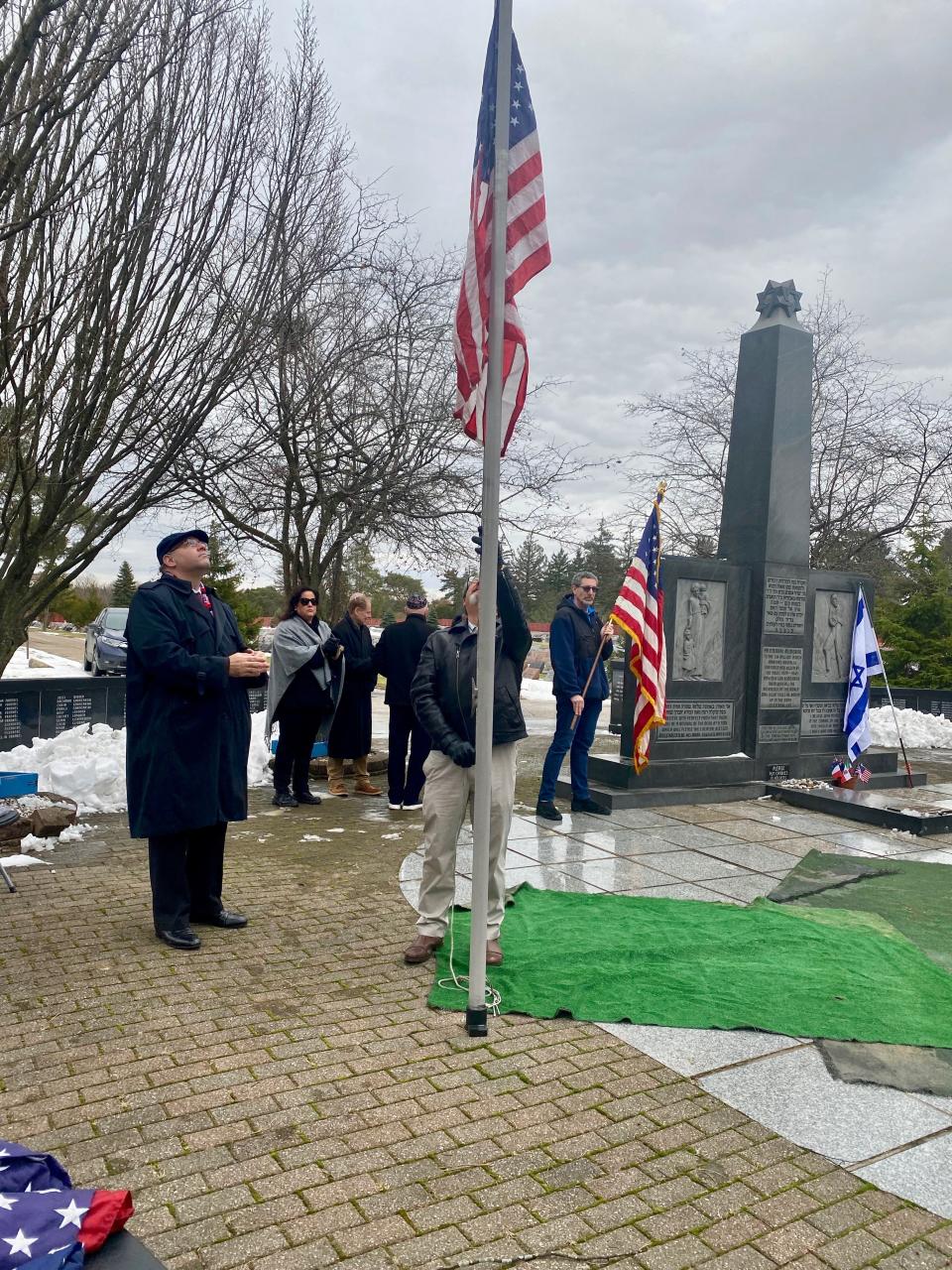 Members of the Kol Israel Foundation raise a U.S. flag on December, 29, 2022, after the Holocaust memorial was given its national designation.