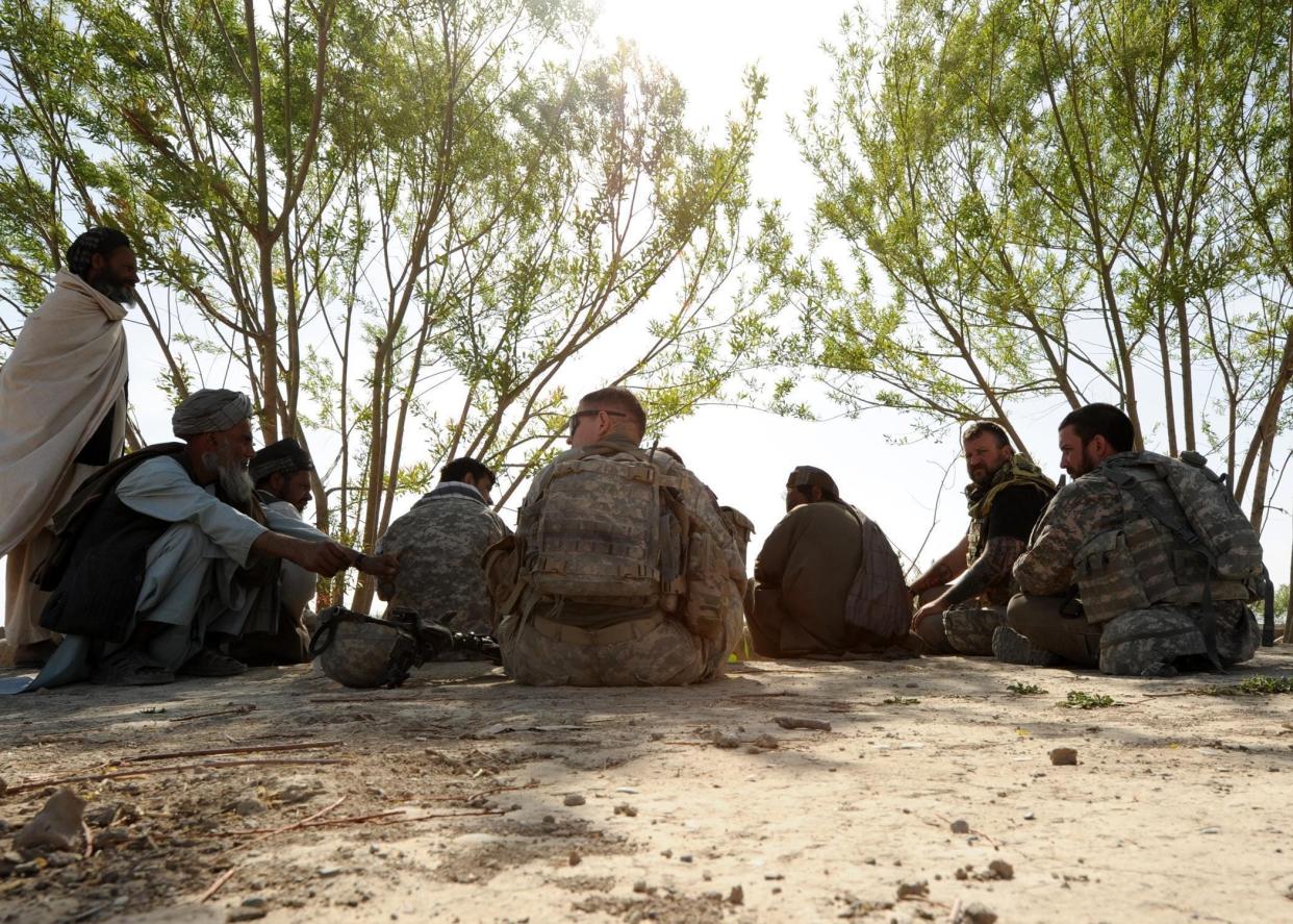 A Human Terrain Team (HTT) consisting of U.S. Army soldiers and civilians, along with an Afghan translator, meet with local citizens of a village near Kandahar Air Field, Afghanistan, April 3, 2013. HTTs are composed of military and civilian personnel that interact with the local populace to gain knowledge, so they may aid in creating a stable environment and learn on how to conduct future military and humanitarian operations.