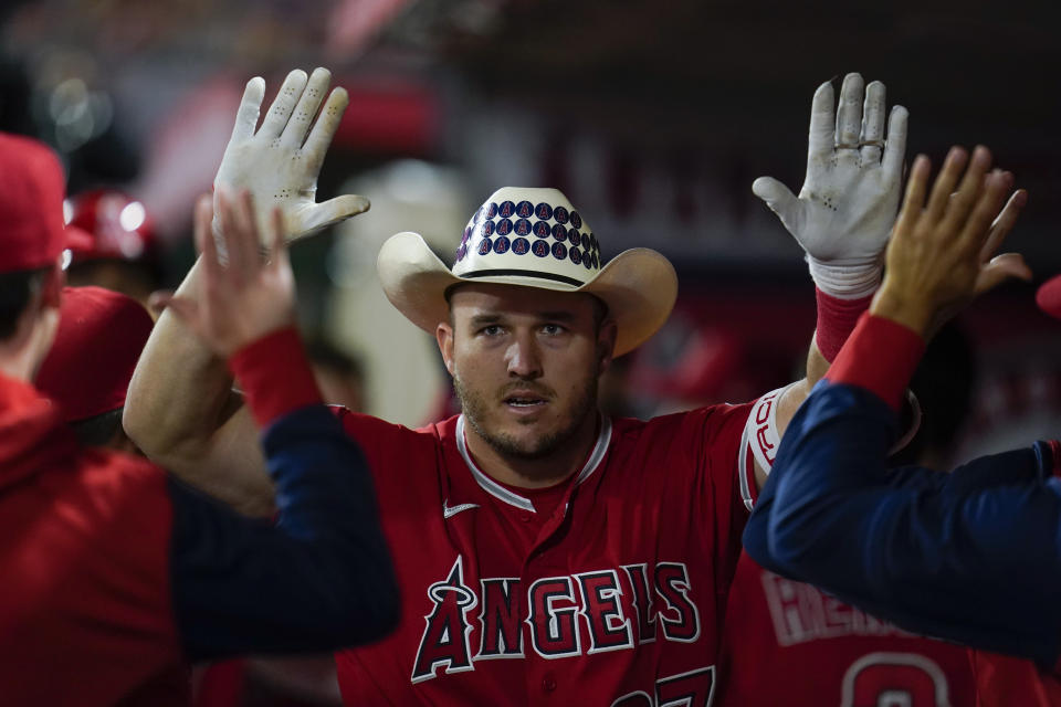 Los Angeles Angels' Mike Trout (27) celebrates in the dugout after hitting a home run during the seventh inning of a baseball game against the Toronto Blue Jays in Anaheim, Calif., Saturday, May 28, 2022. (AP Photo/Ashley Landis)