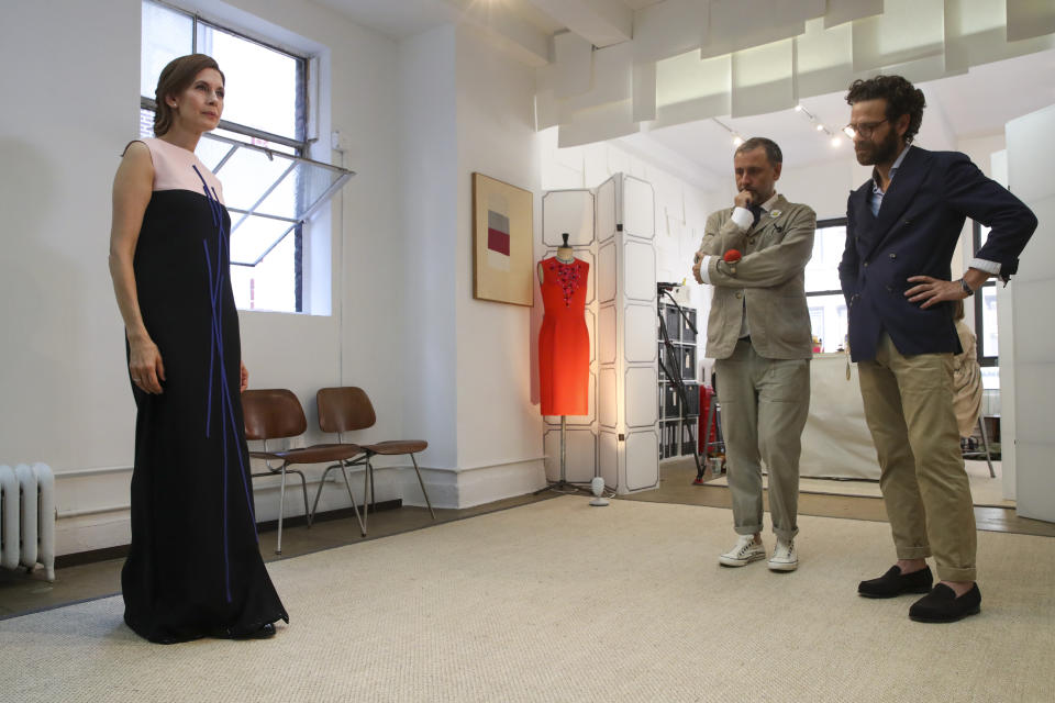 In this Sept. 4, 2019, photo, designer Herve Pierre, center, and Nicolas Caito, right, fit Emmy-nominated actress Jessica Hecht with a dress for her to wear at the Creative Arts Emmy Awards, at Atelier Caito for Herve Pierre in New York. (AP Photo/Mary Altaffer)