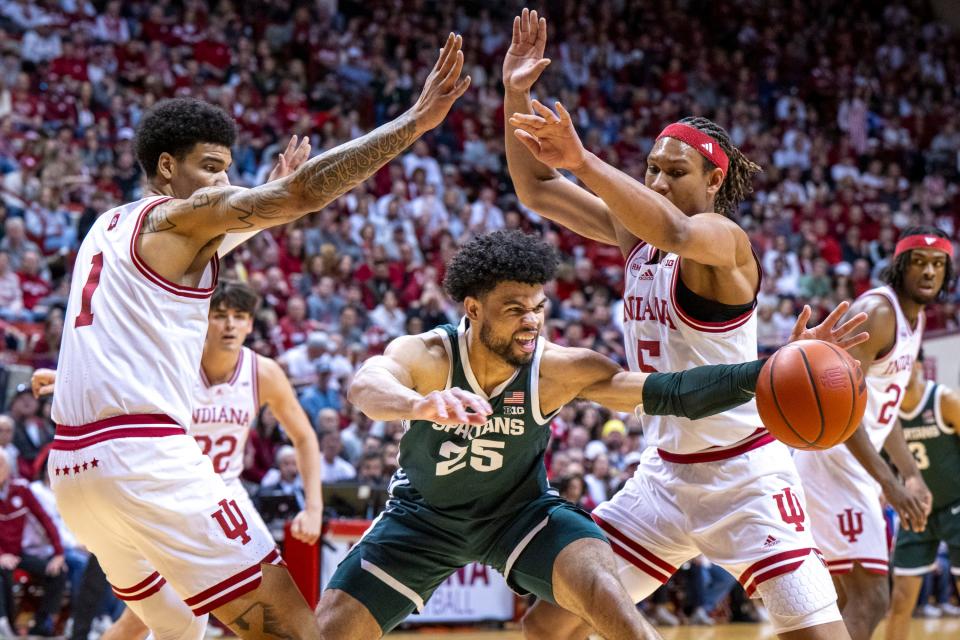 Michigan State forward Malik Hall reaches to regain control of the ball while being defended by Indiana center Kel'el Ware, left, and forward Malik Reneau during the first half on Sunday, March 10, 2024, in Bloomington, Indiana.