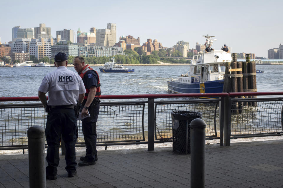 FILE - In this Aug. 5, 2018, file photo, authorities investigate the death of a baby boy who was found floating in the East River near the Brooklyn Bridge in Manhattan in New York. A Bronx father hopped a plane to Thailand after carrying his dead 7-month-old baby around New York City in a backpack and tossing the boy's body into the river and other tourist hotspots, police said Wednesday. (AP Photo/Robert Bumsted, File)